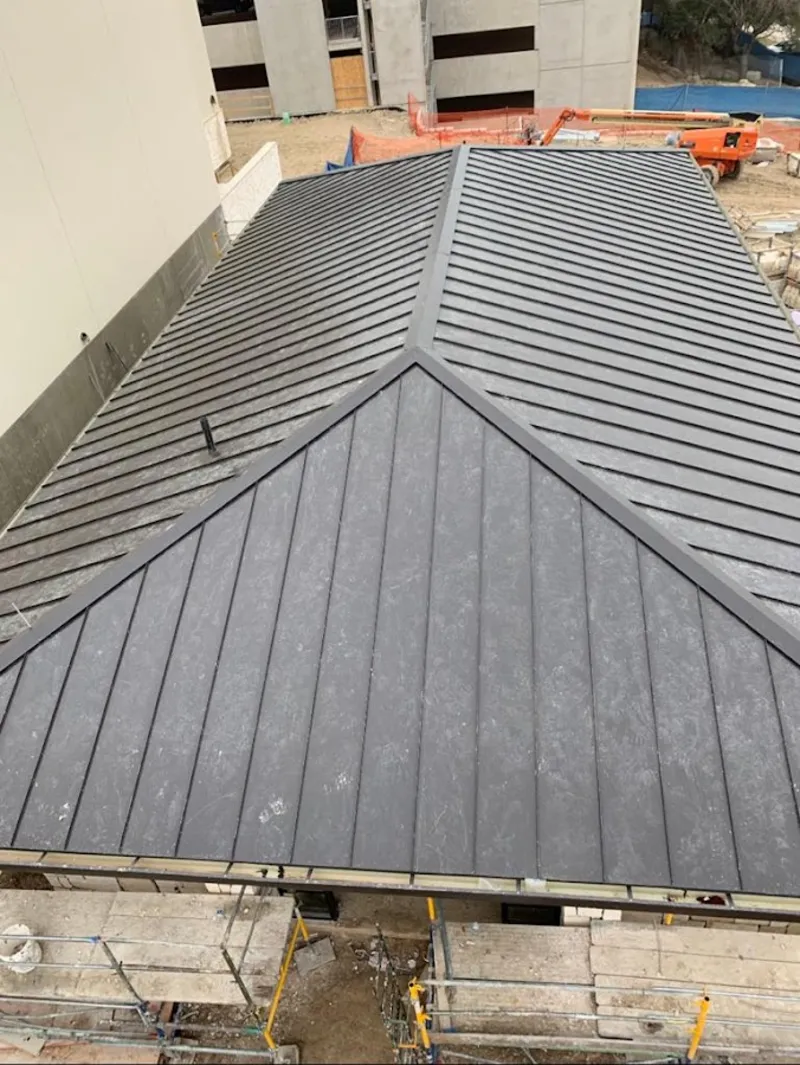 Commercial metal roof construction with crane equipment in Tuttle