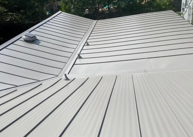 Solar attic fan installed on a metal roof for Roof Ventilation in Tuttle
